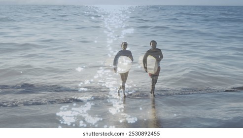 Image of light reflection over happy african american couple with surfboards over seascape. Holidays, vacations and relax concept digitally generated image. - Powered by Shutterstock