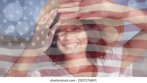 Image of light spots and american flag over biracial woman in sunhat smiling on sunny beach. America, summer, vacations, healthy lifestyle, celebration and patriotism, digitally generated image. - Powered by Shutterstock