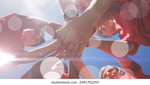 Image of light spots over diverse schoolchildren teaming up with coach at stadium. national school sports week and celebration concept digitally generated image. - Powered by Shutterstock