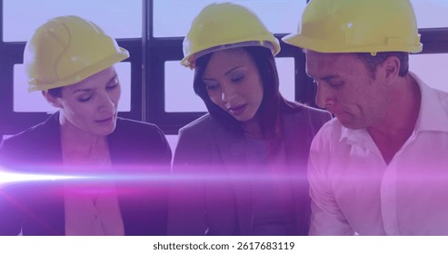 Image of light trails over diverse male and female engineers in office. international women engineering day and celebration concept digitally generated image.