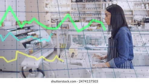 Image of lines and financial data processing over woman serving in shop. Global business, finance, computing and data processing concept digitally generated image.