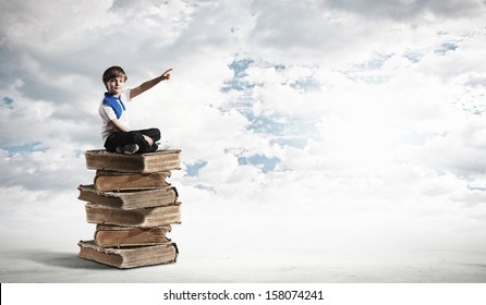 Image Of Little Cute Boy Sitting On Pile Of Books