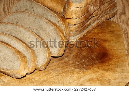 Image of a loaf of bread cut into slices on a kitchen board.