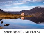 Image of a lone pink house on Loch Glass in the Scottish Highlands