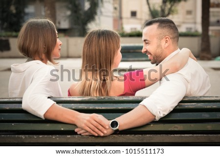 Image of the love triangle between  smiling cheerful  people outdoor