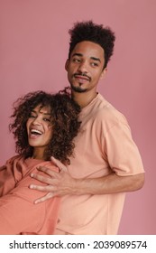 Image Of Lovely Couple People Of African Appearance On Isolated Pink Color. Tall Man With Beautifully Shaved Beard Holds Cheerful Woman With Wide Open Smile By Shoulders.