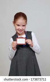 Image Of Lovely Little Girl In A School Uniform With A Name Tag On A Gray Background/Little Girl With A Blank Name Tag