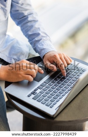 Image of male hands typing on keyboard, selective focus.