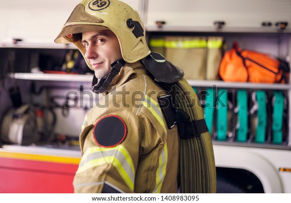 Image of man fireman in helmet on background of\
fire truck