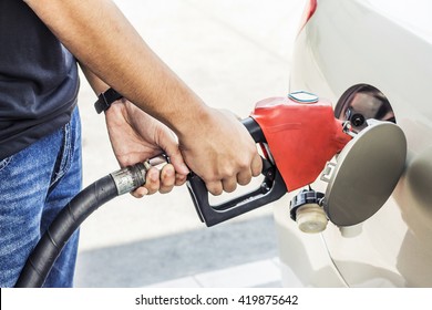 image of a man hands pumping gasoline fuel in car at gas station, self service, concept