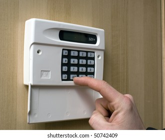 Image Of A Man Setting A Burglar Alarm