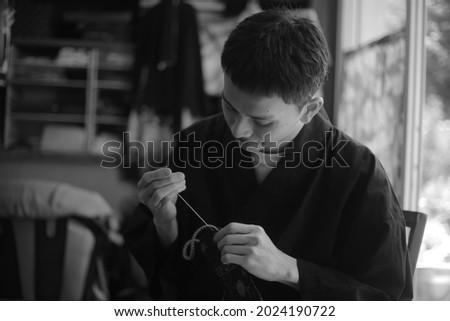 Image of a man sewing 

