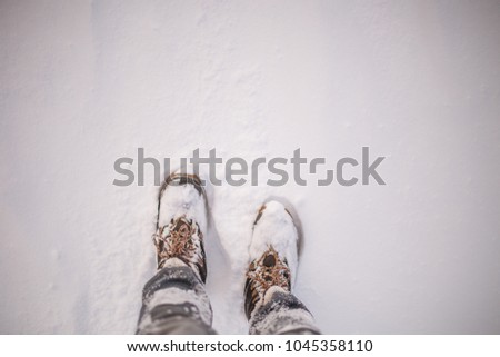 Image of man's feets in boots in snow