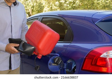 
Image Of A Man's Hands Holding His Empty Wallet With No Money And An Empty Petrol Can Beside The Car Tank. Reference To The Constant Increase In The Price Of Fuels