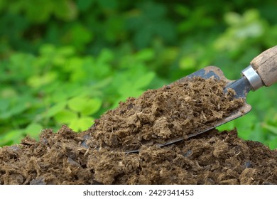 Image of manure with green plants background