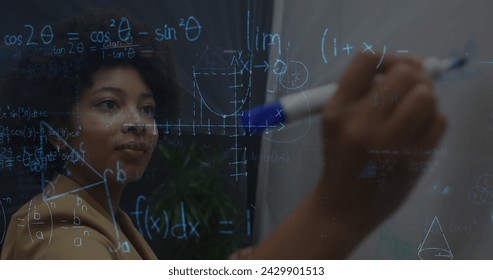 Image of mathematical equations over african american businesswoman taking notes. global networks, business, data processing and digital interface concept digitally generated image. - Powered by Shutterstock