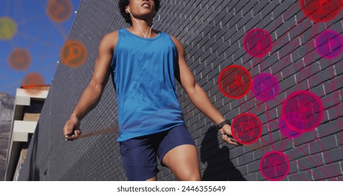 Image of media icons over african american man jumping rope. Global business and digital interface concept digitally generated image.