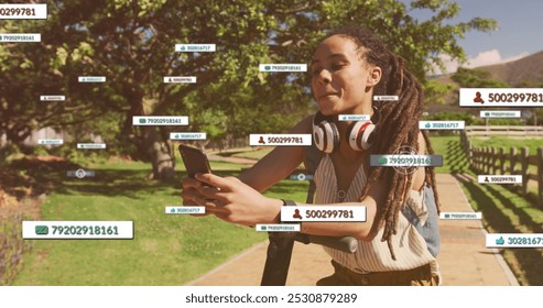 Image of media icons over biracial woman using smartphone with scooter in park. health and fitness concept digitally generated image. - Powered by Shutterstock