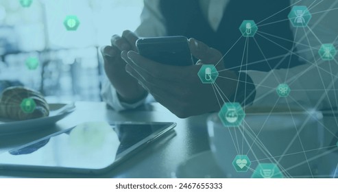 Image of medical icons forming glove and caucasian businessman using mobile phone at desk. Digital composite, healthcare, globalization, hands, technology, digital tablet, business, office, food. - Powered by Shutterstock