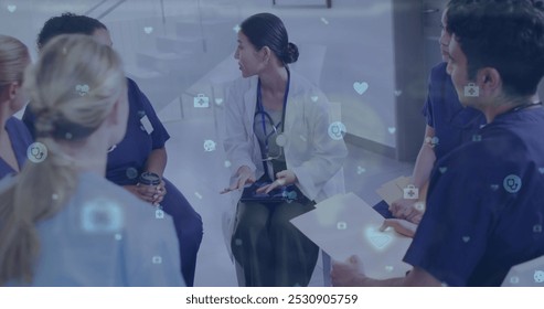 Image of medical icons over asian female doctor talking with diverse colleagues in hospital. Medical and healthcare services concept digitally generated image. - Powered by Shutterstock