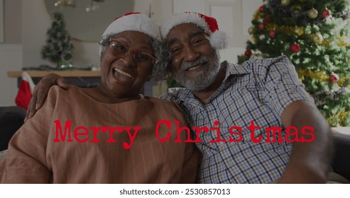 Image of merry christmas text over senior african american couple wearing santa hats. Christmas, tradition and celebration concept digitally generated image. - Powered by Shutterstock