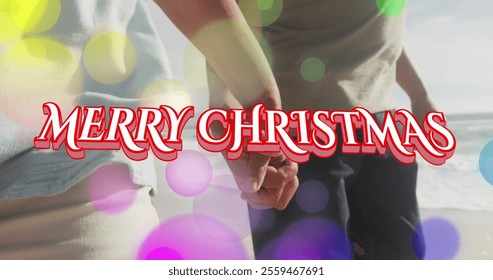 Image of merry christmas text over senior biracial couple at beach. Christmas, celebration and digital interface concept digitally generated image. - Powered by Shutterstock