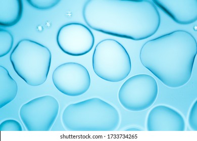 Image From Microscopy Of Water Drops In The Microscopic Slide.Abstract Oxygen Bubbles In The Water.Mixed And Different Shape Background In The Blue Tone.