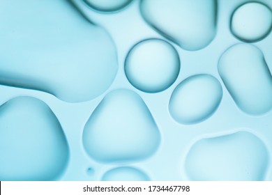 Image From Microscopy Of Water Drops In The Microscopic Slide.Abstract Oxygen Bubbles In The Water.Mixed And Different Shape Background In The Blue Tone.