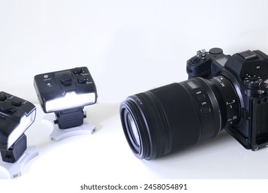 Image of a mirrorless interchangeable lens camera system and wirelessly controlled remote flash gun