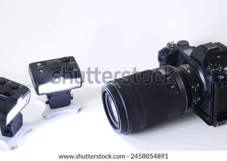 Image of a mirrorless interchangeable lens camera system and wirelessly controlled remote flash gun