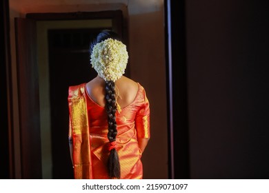An image of a model as a Kerala Hindu Bride in saree, wearing gold and jasmine flower garlands in the hair