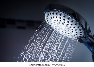 Image of a modern shower head splashing water close up background.