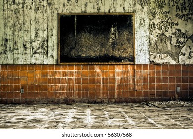 Image Of A Moldy Black Corkboard In A Derelict Abandoned Building On A Wall With Peeling Paint And Scratched Tile.