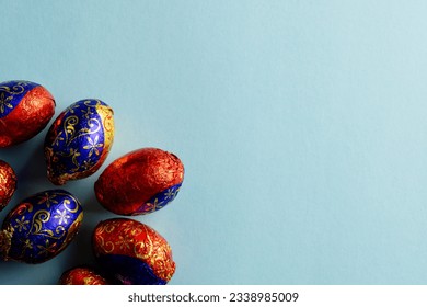 Image of multi coloured chocolate easter eggs with copy space on blue background. Easter, religion, tradition and celebration concept. - Powered by Shutterstock