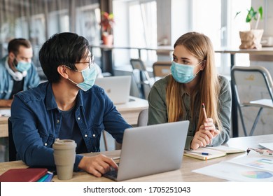 Image Of Multinational Focused Students In Protective Mask Talking While Studying With Laptop At Classroom