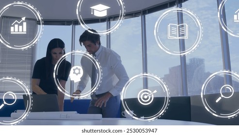 Image of multiple digital icons against diverse man and woman discussing over a plan at office. Computer interface and business technology concept - Powered by Shutterstock