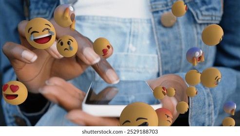 Image of multiple face emojis floating over mid section of a woman using smartphone. Social media networking technology concept - Powered by Shutterstock