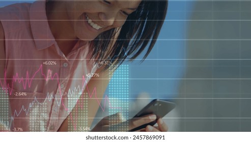Image of multiple graphs with changing numbers over smiling biracial woman using smartphone. Digital composite, multiple exposure, report, business, growth and technology concept.