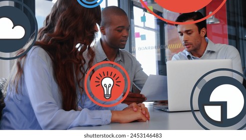 Image of multiple icons over diverse coworkers discussing reports on laptop in office. Digital composite, multiple exposure, business, ideas, globalization, teamwork and technology concept. - Powered by Shutterstock