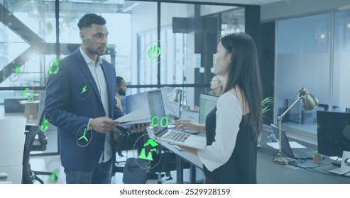 Image of multiple icons over diverse coworkers standing and discussing reports in office. Digital composite, multiple exposure, business, hazardous, pollution, teamwork and technology concept. - Powered by Shutterstock