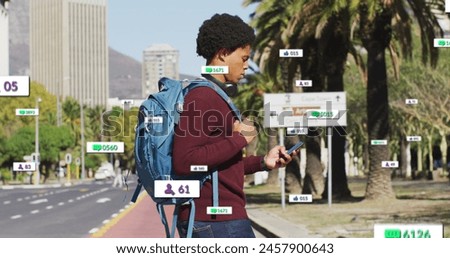 Image of multiple notification bars over biracial man holding cellphone crossing street. Digital composite, multiple exposure, business, growth, social media reminder and technology concept.