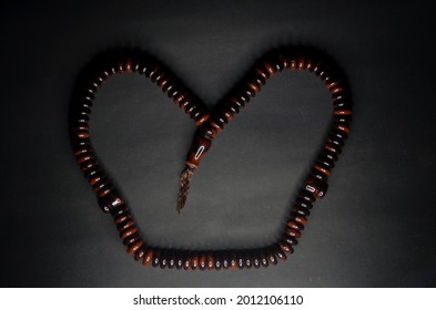 An image of Muslim Tasbih Prayer Beads Palm Seeds Islamic Prayer Zikr Misbaha isolated with black background.
