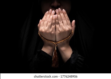 The image of a Muslim woman's hand, Islamic prayer, and her hand holding a rosary beads or tasbih. - Powered by Shutterstock