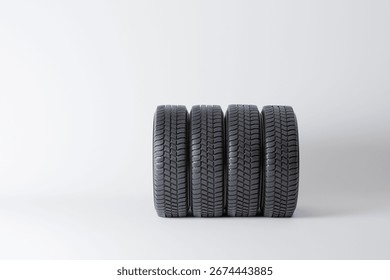 Image of a neatly arranged stack of four car tires, highlighting their tread patterns and robust design, suitable for automotive or tire marketing concepts, showcasing quality and performance.