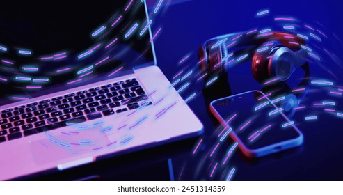 Image of neon light trails over image game computer equipment. Global image game, digital interface, data processing and connections concept digitally generated image.
