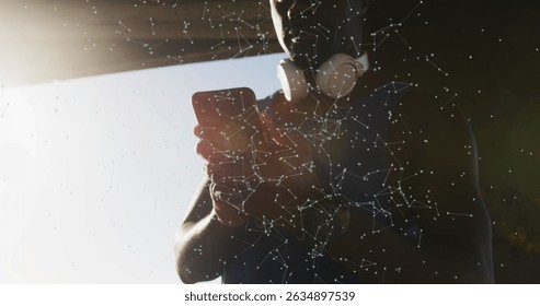 Image of network of connections over african american man using smartphone. Global networks, digital interface and social media concept digitally generated image.