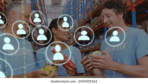 Image of network of icons with binary coding over diverse volunteers in warehouse. Global networks, business, finances, computing and data processing concept digitally generated image.