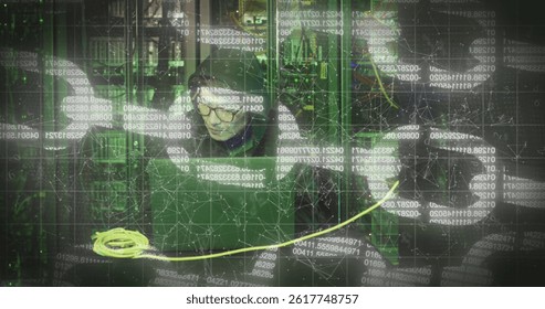 Image of nft text over asian male hacker in server room. global technology and digital interface concept digitally generated image.