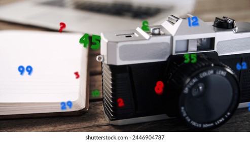 Image of numbers changing over close up of desk with camera and laptop. digital interface global connection and communication concept digitally generated image.