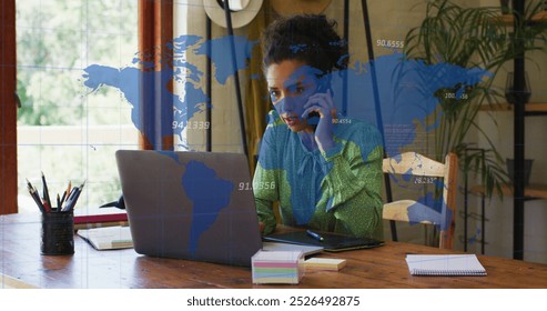 Image of numbers, map over biracial woman talking on cellphone and working on laptop at office. Digital composite, multiple exposure, global, digits, business, communication and technology. - Powered by Shutterstock